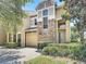 Beautiful home exterior with stone accents, arched windows, lush landscaping, and a brick paver driveway at 2012 Gold Spring Cv, Kissimmee, FL 34743