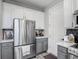 Kitchen with stainless steel refrigerator, white cabinets above gray cabinets, and modern backsplash at 2012 Gold Spring Cv, Kissimmee, FL 34743