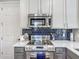 Kitchen with stainless steel appliances, stylish backsplash, white countertops, and ample cabinet space at 2012 Gold Spring Cv, Kissimmee, FL 34743