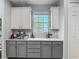 Kitchen area with white and gray cabinets and countertops with a large window for natural light at 2012 Gold Spring Cv, Kissimmee, FL 34743