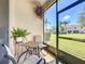 Screened lanai with seating area, offering a relaxing outdoor space with views of the lush yard at 2012 Gold Spring Cv, Kissimmee, FL 34743
