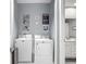 Functional laundry area adjacent to a bathroom, featuring a washer and dryer with decor at 2012 Gold Spring Cv, Kissimmee, FL 34743