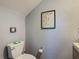Simple powder room with gray walls, a toilet, wall art, and a partial view of the vanity at 2012 Gold Spring Cv, Kissimmee, FL 34743