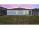 View of backyard featuring the home's exterior, covered patio, and lush lawn at 2308 Glenbrook Chase Blvd, Lakeland, FL 33811