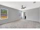 Spacious carpeted bedroom with a ceiling fan and views from two bright windows at 2308 Glenbrook Chase Blvd, Lakeland, FL 33811