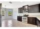 Kitchen with dark wood cabinetry, granite countertops, stainless steel appliances, and tile floors at 2308 Glenbrook Chase Blvd, Lakeland, FL 33811