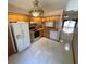 Functional kitchen with wooden cabinets, white appliances, and white tile flooring at 2348 Sun Valley Cir, Winter Park, FL 32792