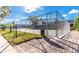 Outdoor tennis court enclosed by a chain-link fence, with well-maintained landscaping and a paved walkway at 2348 Sun Valley Cir, Winter Park, FL 32792