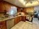 Functional kitchen with oak cabinets, tiled countertops, and modern appliances at 240 Slade Dr, Longwood, FL 32750