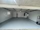 View of the spacious, painted garage with garage door and water heater at 2435 W Park Dr., Deland, FL 32724