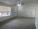 Cozy living room with carpeted floors, a ceiling fan, and natural light from the window at 2435 W Park Dr., Deland, FL 32724