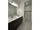 Bathroom featuring double sink vanity with granite counters and modern fixtures with access to tub at 2741 Nottel Dr, St Cloud, FL 34772