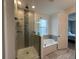 Modern bathroom featuring a glass shower and soaking tub with tiled walls and floors at 2741 Nottel Dr, St Cloud, FL 34772
