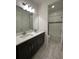 Bright bathroom featuring double sinks, sleek cabinetry, and tile flooring and backsplash at 2741 Nottel Dr, St Cloud, FL 34772