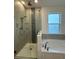 The bathroom has a glass enclosed shower and soaking tub with stylish tiled walls and modern fixtures at 2741 Nottel Dr, St Cloud, FL 34772