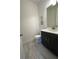 Modern half bathroom featuring a dark vanity, stylish mirror, and tiled floors at 2741 Nottel Dr, St Cloud, FL 34772