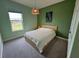 Cozy bedroom with fresh green paint, a woven light fixture, and a large window with a view at 2741 Nottel Dr, St Cloud, FL 34772
