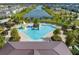 Aerial view of a vibrant community pool area with splash pad, palm trees, and ample seating for residents at 2741 Nottel Dr, St Cloud, FL 34772