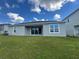 Home exterior showcases a well-maintained lawn leading to a sliding glass door at 2741 Nottel Dr, St Cloud, FL 34772