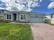 Charming single Gathering home with a brick driveway, two-car garage, and manicured lawn under a cloudy blue sky at 2741 Nottel Dr, St Cloud, FL 34772