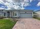 Charming single Gathering home with a brick driveway, two-car garage, and manicured lawn under a cloudy blue sky at 2741 Nottel Dr, St Cloud, FL 34772