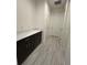 Hallway with gray tile, a storage cabinet, and white trim at 2741 Nottel Dr, St Cloud, FL 34772