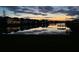 Scenic evening view of a tranquil pond reflecting the sunset, with homes illuminated in the background at 2741 Nottel Dr, St Cloud, FL 34772