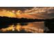 Gorgeous sunset view over a tranquil lake, casting a golden glow on the water and surrounding community at 2741 Nottel Dr, St Cloud, FL 34772