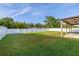 Expansive backyard featuring a large lawn area, a white fence line, and a covered patio at 305 Kays Landing Dr, Sanford, FL 32771