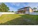 Expansive backyard featuring a large lawn area, a white fence line, and a covered patio at 305 Kays Landing Dr, Sanford, FL 32771