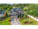 Aerial view of a well-manicured home showcasing lush landscaping, a brick driveway, and an inviting facade at 305 Kays Landing Dr, Sanford, FL 32771