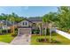 Beautiful two-story home with mature landscaping, including palm trees, and a brick driveway leading to a two-car garage at 305 Kays Landing Dr, Sanford, FL 32771