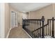 Upstairs hallway leading to rooms with wood-look floors and dark wood banister at 305 Kays Landing Dr, Sanford, FL 32771