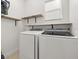 Bright laundry room with front load washer and dryer with wood shelving at 305 Kays Landing Dr, Sanford, FL 32771