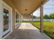 A view of the patio with its covered area, and the grass yard extending to a white fence at 305 Kays Landing Dr, Sanford, FL 32771
