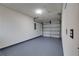 Spacious garage featuring a smooth painted floor, with white walls, and a functional roll-up door at 312 Oak Track Ter, Ocala, FL 34472