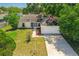 Aerial view of a home with mature trees, a two car garage and driveway at 3205 Clewiston St, Deltona, FL 32738