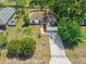Charming aerial view of a house with a two car garage, driveway, and mature landscaping at 3205 Clewiston St, Deltona, FL 32738
