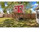 Whimsical backyard showcasing a charming red treehouse with a ladder and small porch at 3205 Clewiston St, Deltona, FL 32738