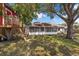Large backyard featuring a screened porch and a custom red treehouse nestled among the trees at 3205 Clewiston St, Deltona, FL 32738