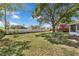 Spacious backyard with a well-maintained lawn, a privacy fence, and a charming red treehouse at 3205 Clewiston St, Deltona, FL 32738