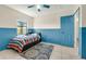 Bedroom featuring color block walls, a ceiling fan, and a blue door at 3205 Clewiston St, Deltona, FL 32738