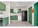 View of the kitchen showcasing green cabinets, a black refrigerator, and tiled flooring at 3205 Clewiston St, Deltona, FL 32738