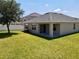 Spacious backyard with a covered patio, ample green space, and a privacy fence, perfect for outdoor relaxation at 3702 Maidencain St, Clermont, FL 34714