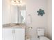 Clean bathroom with a single sink, white cabinets, and decorative flower wall decor at 416 Southfield St, Kissimmee, FL 34747