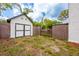 Fenced backyard featuring a white storage shed and gate access to a carport at 420 N Center St, Eustis, FL 32726