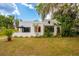 Charming stucco home featuring a red front door, well-manicured lawn, and lush landscaping at 420 N Center St, Eustis, FL 32726