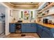 Beautiful kitchen with custom blue cabinets, wood countertops, and a decorative stained-glass window at 420 N Center St, Eustis, FL 32726