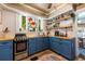 Stylish kitchen featuring blue cabinets, wood countertops, and floating shelves at 420 N Center St, Eustis, FL 32726