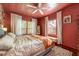 Well-lit main bedroom features three windows, a ceiling fan, and a floral comforter at 420 N Center St, Eustis, FL 32726